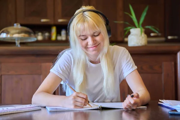 Porträt eines jugendlichen Studentenmädchens mit Kopfhörern, das zu Hause lernt — Stockfoto