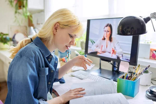 Adolescente chica estudiando en casa en línea utilizando la computadora — Foto de Stock