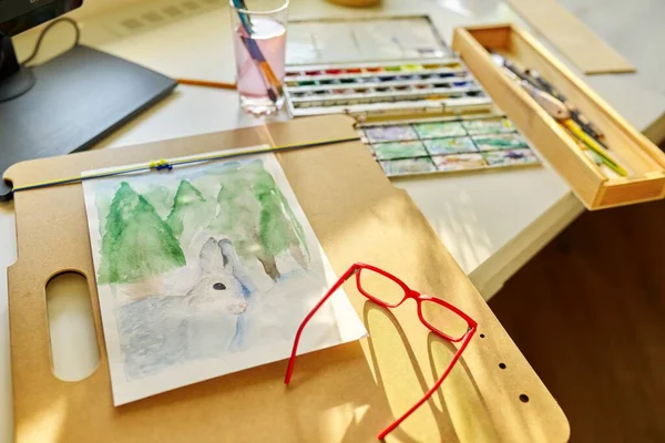 Watercolor drawing, glasses, watercolors in a box, brushes on the table, nobody — Fotografia de Stock