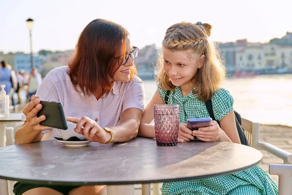 Mãe e filha criança juntos em um café ao ar livre na orla. — Fotografia de Stock