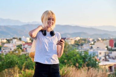 Portakal desenli, mavi gökyüzü geçmişi olan mutlu genç bir kadın.