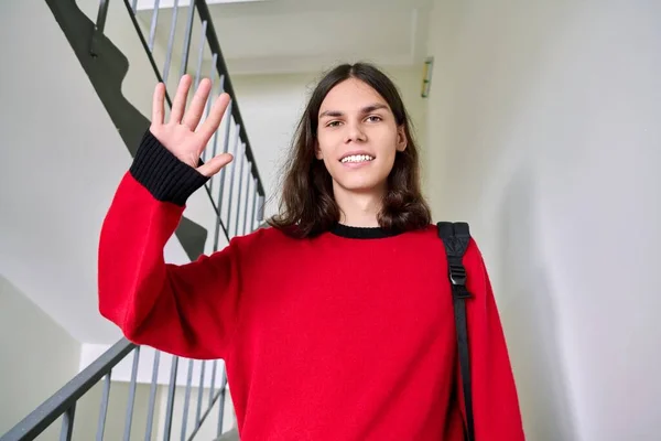 Портрет усміхненого студента з рюкзаком махаючи рукою привітання — стокове фото