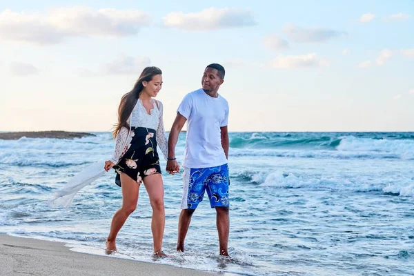 Νεαρό ευτυχισμένο ζευγάρι με τα πόδια στην παραλία κρατώντας τα χέρια, αντίγραφο χώρο — Φωτογραφία Αρχείου