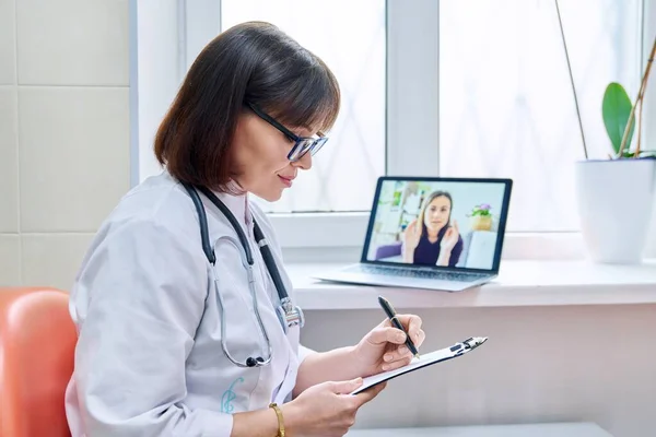 Médico de clínica geral falando em videoconferência com paciente do sexo feminino — Fotografia de Stock