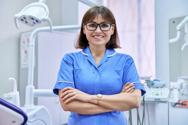 Портрет усміхненої медсестри, яка дивиться на камеру в стоматології . — стокове фото
