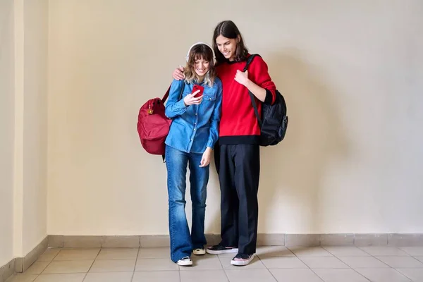 Tiener jongen en meisje op zoek naar smartphone samen. — Stockfoto