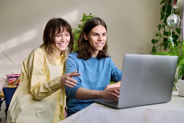 Adolescente amigos masculino e feminino usando laptop em casa para lazer — Fotografia de Stock