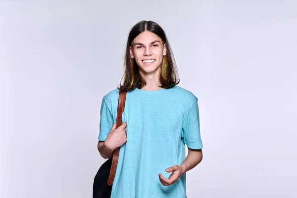 Porträt eines positiven Studenten mit Rucksack, der in die Kamera schaut, Studiohintergrund — Stockfoto