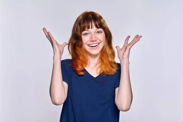 Portrait de jeune femme gaie aux cheveux roux sur fond studio clair — Photo