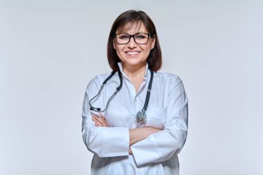 Işık stüdyosunun arka planında kameraya bakan kadın doktorun portresi