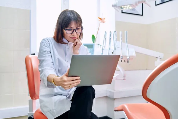 Online consult, doktershulp in de kliniek met laptop. — Stockfoto