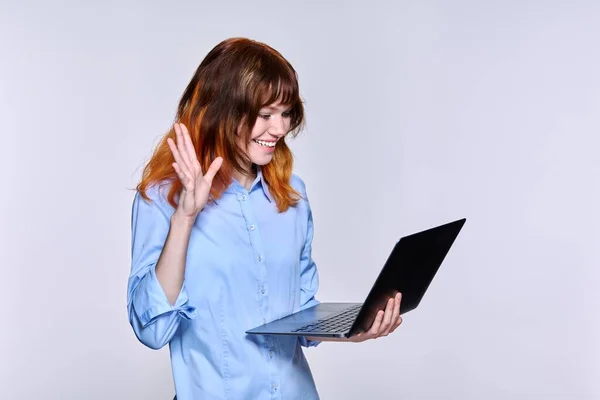 젊은 빨간 머리 여자가 노트북을 사용하여 컨퍼런스 비디오 전화, 라이트 스튜디오 배경 — 스톡 사진