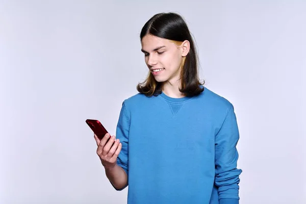 Kerl mit Smartphone in der Hand, auf hellem Studiohintergrund — Stockfoto