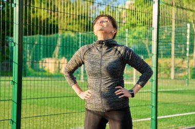 Sportif, olgun bir kadın spor stadyumunda antrenmandan, koşudan, egzersizden sonra...