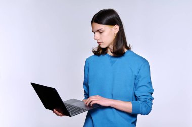 Laptop kullanan genç erkek öğrenci, hafif stüdyo geçmişi var.