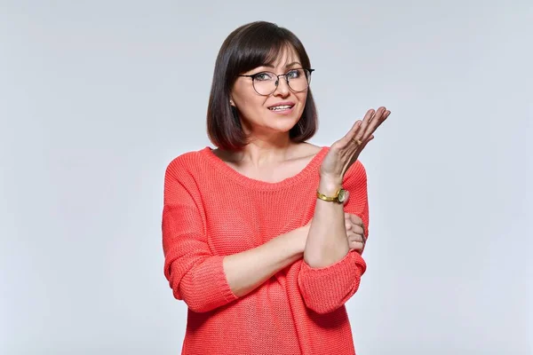 Retrato de una mujer madura hablando, mirando a la cámara, en el fondo del estudio de luz —  Fotos de Stock