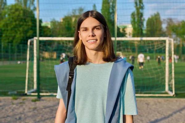 Outdoor portrait of student boy 17, 18 years old, in sunset on school football field — Stock Fotó