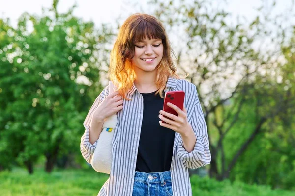 Εξωτερική πορτρέτο του trendy νεαρή κοκκινομάλλα κορίτσι με smartphone στο χέρι — Φωτογραφία Αρχείου