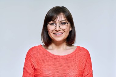 Işık stüdyosunun arka planında, kameraya bakan orta yaşlı kadının portresi