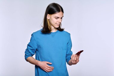 Stüdyo arka planında akıllı telefonu olan bir adam.