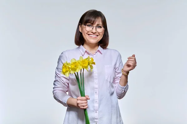 Portrait of middle aged woman with bouquet of flowers looking at camera — Stock Photo, Image