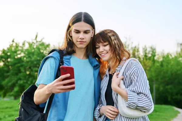 Paar befreundeter College-Studenten schaut auf Smartphone-Bildschirm im Freien — Stockfoto