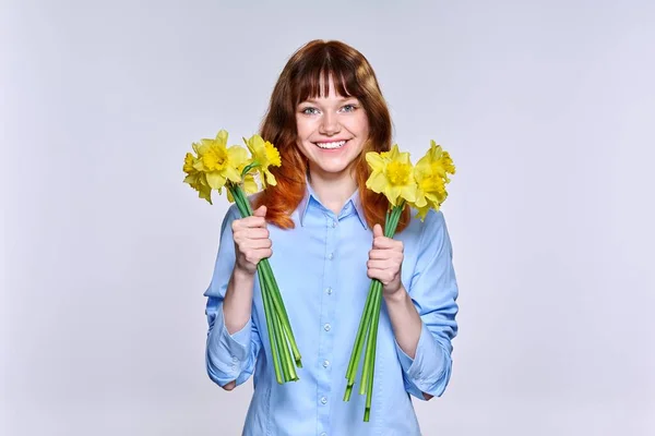 Portrait de jeune femme avec bouquet de fleurs jaunes regardant la caméra — Photo