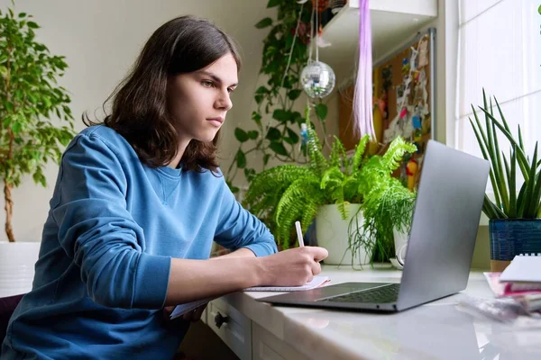 Adolescente studente di sesso maschile che studia a casa con un computer portatile — Foto Stock