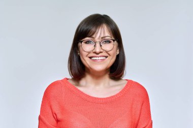 Gülümseyen orta yaşlı bir kadının kamera karşısında fotoğrafı.