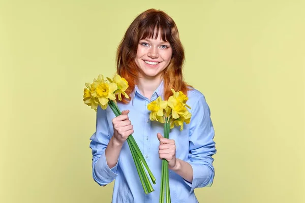 带着一束黄色花朵看着相机的年轻女子的画像 — 图库照片