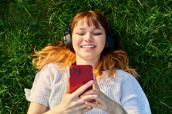 Horní Pohled Tvář Zrzavé Mladé Dospívající Ženy Sluchátkách Chytrým Telefonem — Stock fotografie