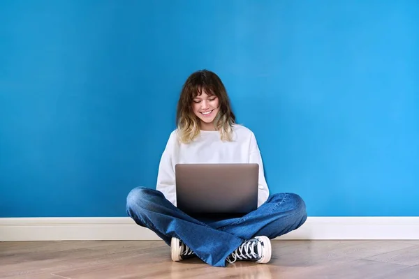 Mulher Adolescente Bonita Sentada Chão Com Laptop Fundo Azul Adolescente — Fotografia de Stock