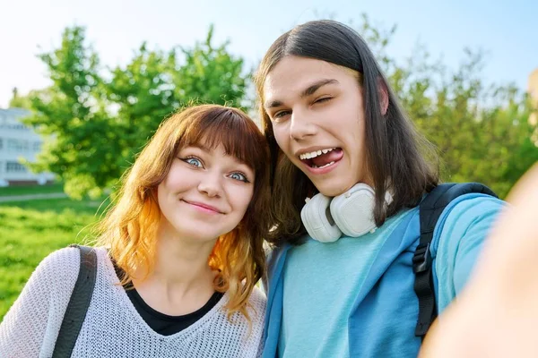 若い十代の友人の男と女の子は 顔を作り 自撮り写真を撮る 楽しさを持っています 若者のカップルは休暇 公園の空の背景を楽しむ 楽しさ 幸福の概念 — ストック写真