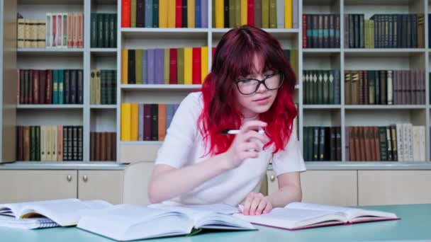 Okul Kütüphanesinde Çalışan Gözlüklü Genç Kız Öğrenci Masada Elinde Kitaplarla — Stok video