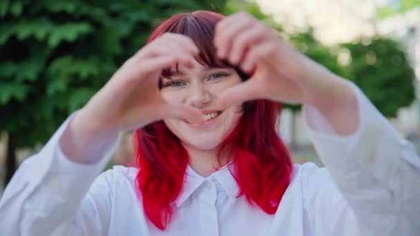 Όμορφη Ευτυχισμένη Έφηβη Κοπέλα Δείχνει Την Καρδιά Σημάδι Χέρια Υπαίθρια — Αρχείο Βίντεο