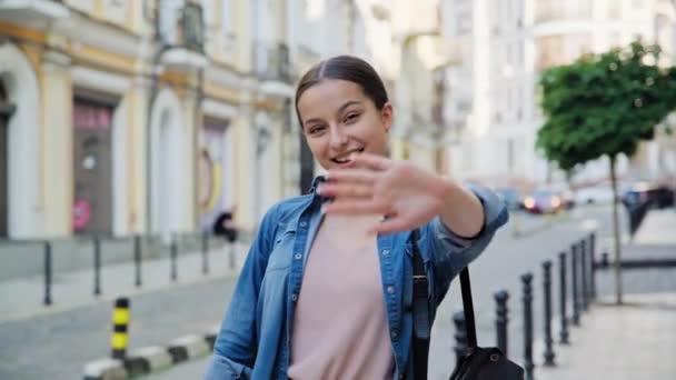 Vackra Leende Tonåring Flicka Viftande Hand Tittar Kameran Utomhus Stadens — Stockvideo