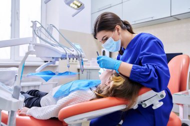 Kadın dişçi, dişlerini anestezi kullanarak tedavi ediyor. Tedavi, dişçilik, çocuklar, sağlık, diş bakımı kavramı