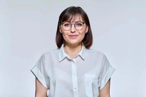 照片上的中年妇女面带微笑 戴着眼镜 身穿衬衫 在灯光下看着相机的正面女性 生活方式 40多岁的人的概念 — 图库照片