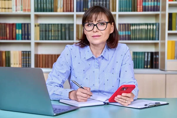 Professora Meia Idade Trabalhando Biblioteca Olhando Para Câmera Usando Laptop — Fotografia de Stock