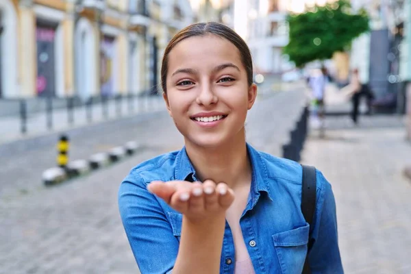 美丽的少女在城市街道上 手牵着手 看着相机 展示着她的空气之吻 符号手势的概念 — 图库照片