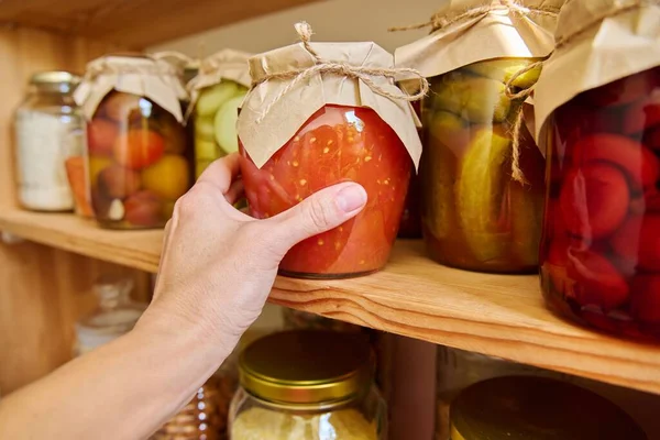 鍋に台所で食品の保管 棚の上に缶詰の野菜や果物 トマトの瓶を閉じます 家庭での料理 自家製の保存 — ストック写真