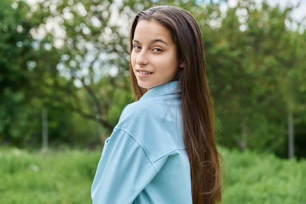 一个15岁的漂亮少女的户外肖像 在绿草的背景下 微笑着看着公园里的相机 青春期 年龄概念 — 图库照片