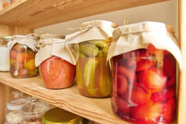 鍋に台所で食品の保管 棚の上の缶詰の野菜や果物 キュウリの瓶を閉じます 家庭での料理 自家製の保存 — ストック写真