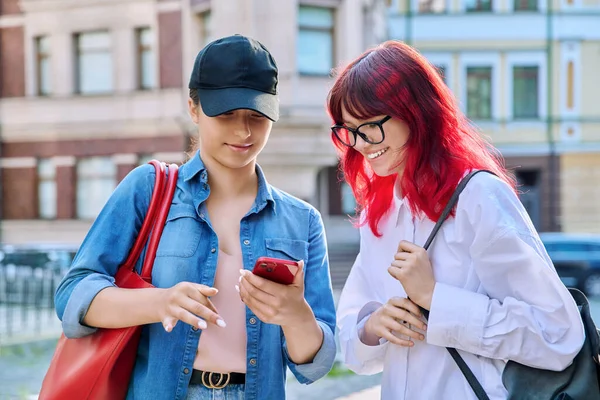 Δύο Έφηβες Γυναίκες Μιλάνε Ψάχνουν Για Smartphone Έξω Στο Δρόμο — Φωτογραφία Αρχείου