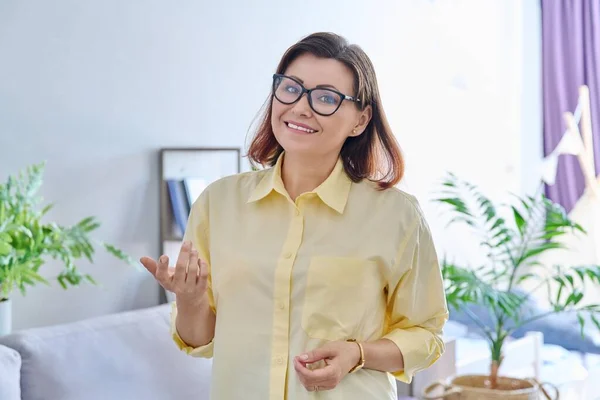 Portrait of confident middle aged business woman in office. Female psychologist, counselor, specialist, manager with folded hands looking at camera. Job, profession, therapy, mature people concept