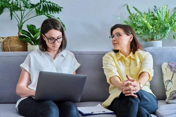 Middle-aged woman in individual therapy session in psychologist office. Consellor talking, taking notes with mature patient. Psychology, mental health, counseling, social work, psychotherapy concept