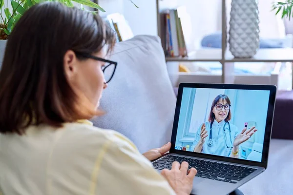 Woman making video call with doctor, online meet consultation at home. Female using laptop for chat conference, doctor on screen. Technology, medicine, health care, people concept