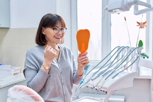 Щаслива Жінка Середнього Віку Стоматолог Пацієнт Дзеркалом Руках Дивиться Зуби — стокове фото