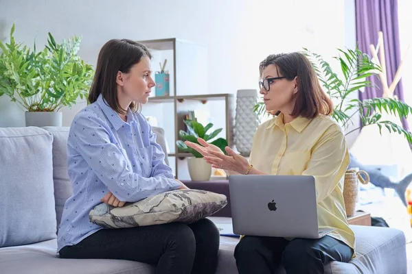 Psikolog ofisinde bireysel terapi gören genç bir kadın. Konuşan notlar alan olgun bayan danışman. Psikoloji, psikiyatri, tedavi, akıl sağlığı konsepti