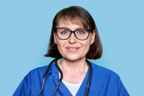 Enfermeira Meia Idade Uniforme Azul Com Estetoscópio Sorrindo Olhando Para — Fotografia de Stock